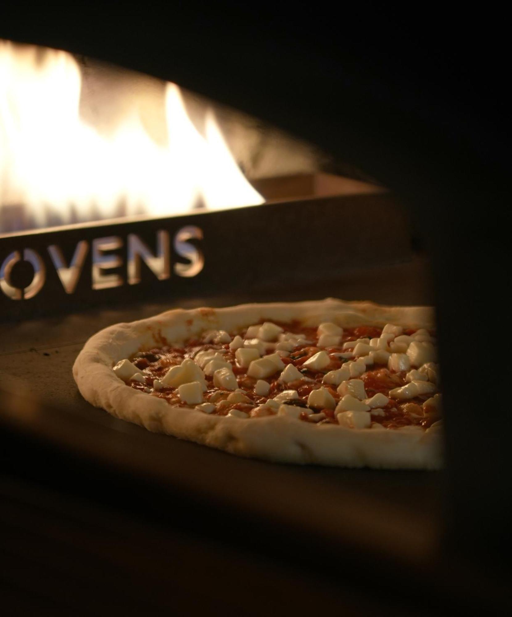 Fairmont Rijád Kültér fotó A pizza in a wood-fired oven