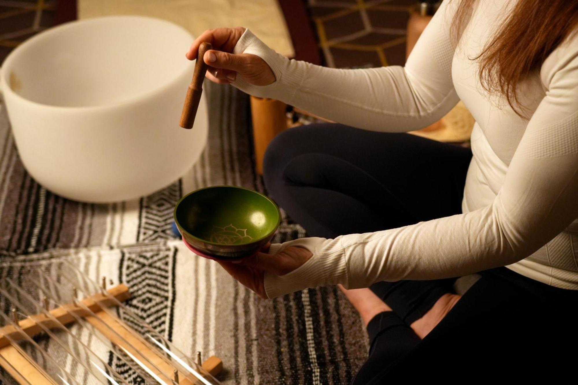Fairmont Rijád Kültér fotó A woman playing a singing bowl