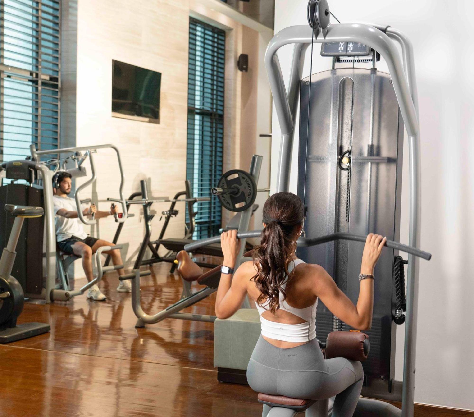 Fairmont Rijád Kültér fotó A woman using a lat pulldown machine