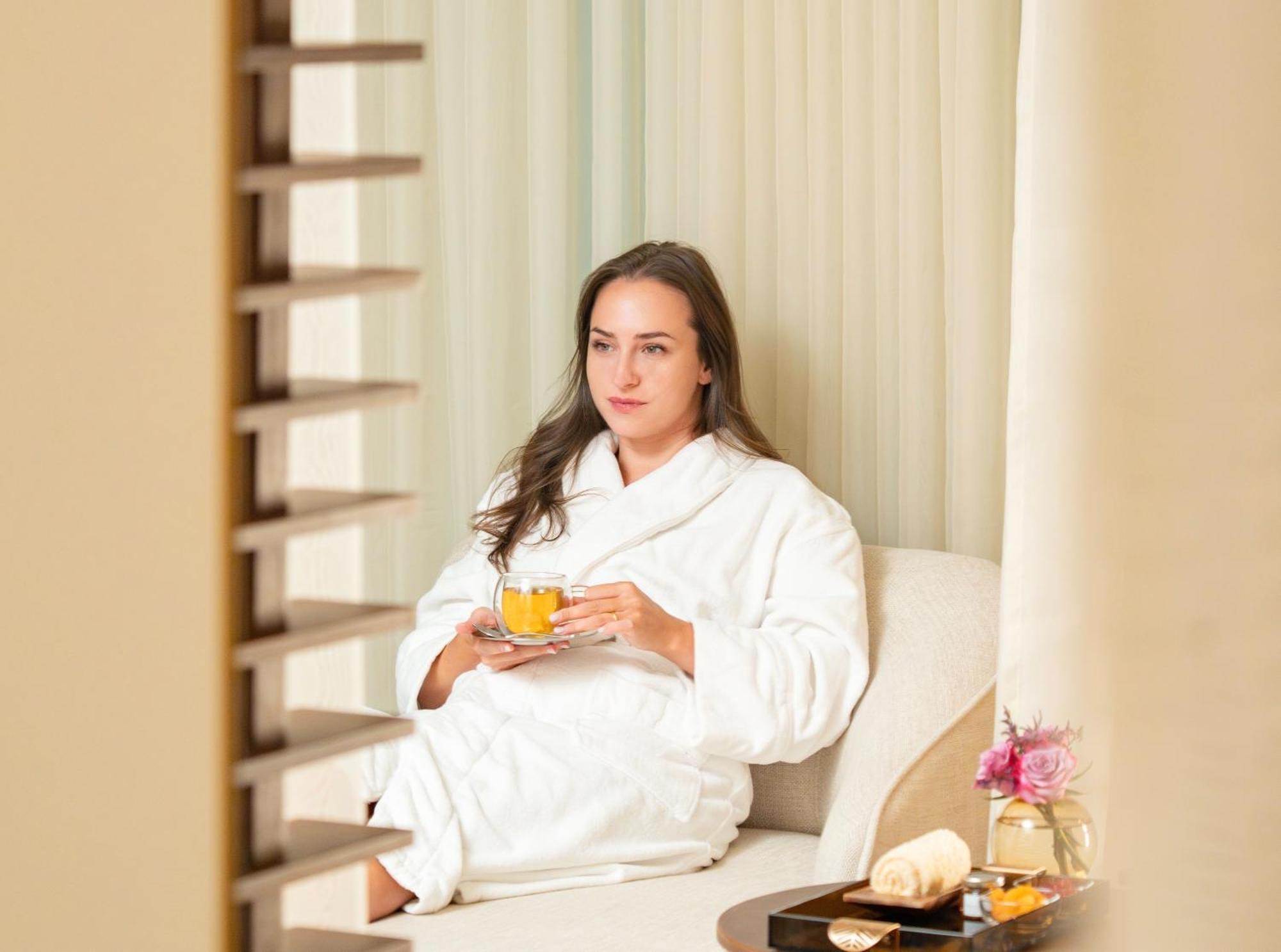 Fairmont Rijád Kültér fotó A woman wearing a bathrobe